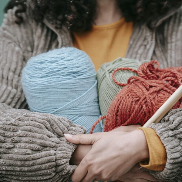 Woman with skein of colorful yarn and knitting needles